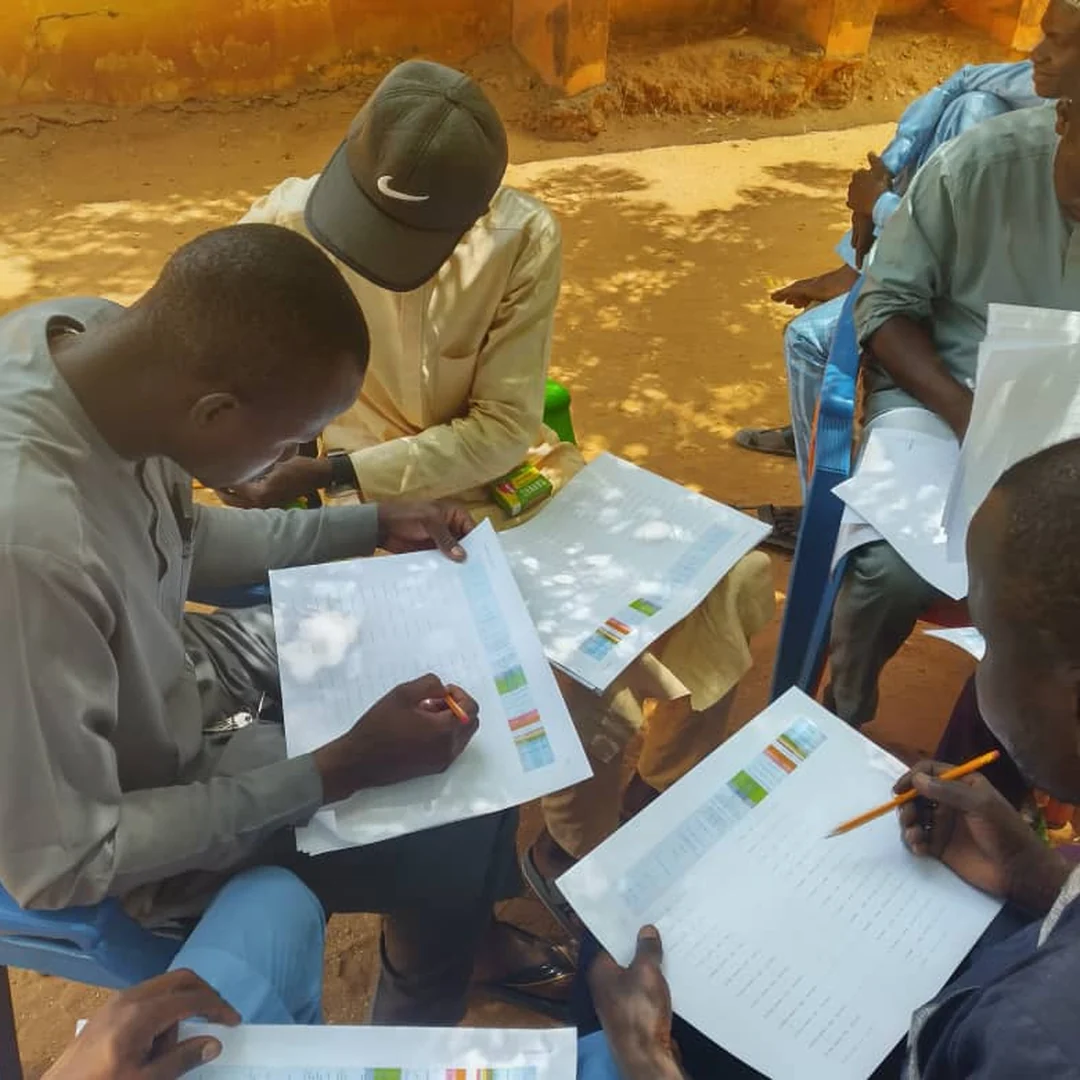 Microplanning team reviewing immunisation maps and settlement data
